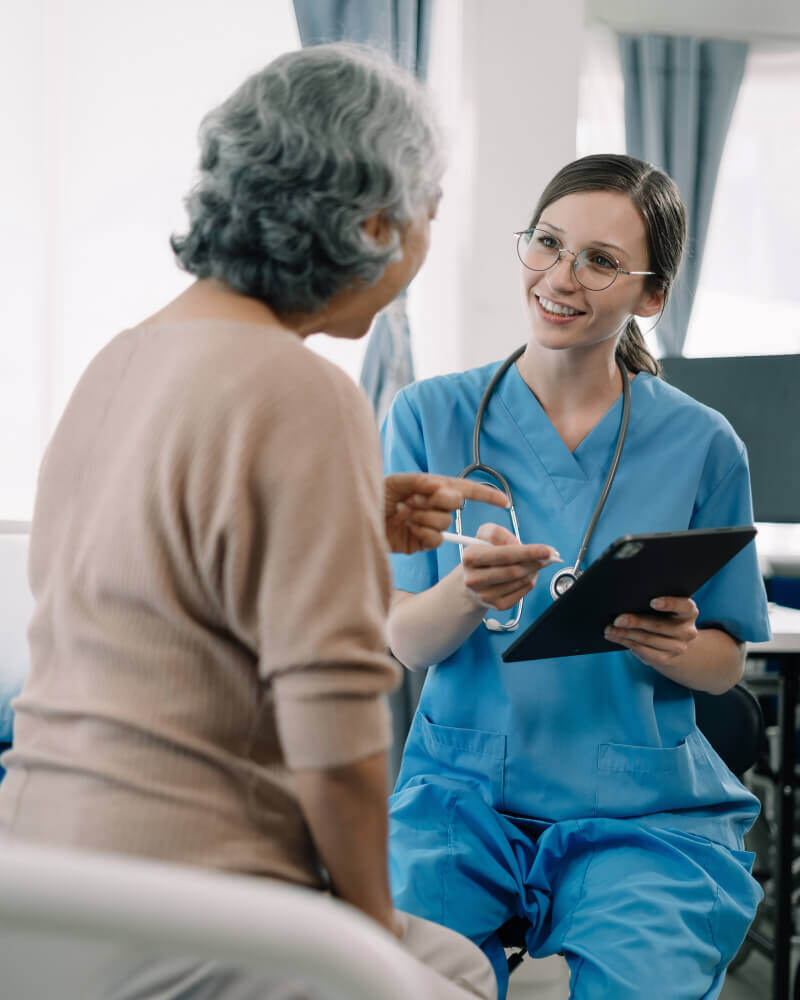 White Female Doctor in blue uniform with elderly patient