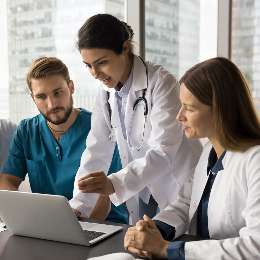 Team of doctors looking at laptop with negotiation and credentialing pricing