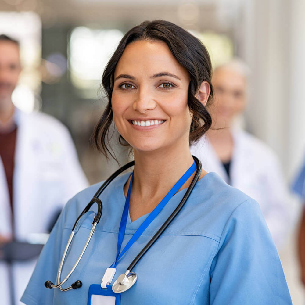 Female doctor in blue scrubs smiling at camera