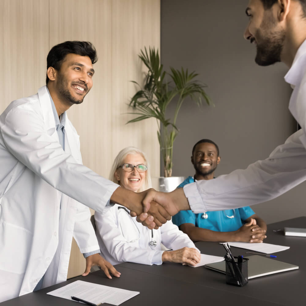 Young Indian doctor shaking hands after credentialing